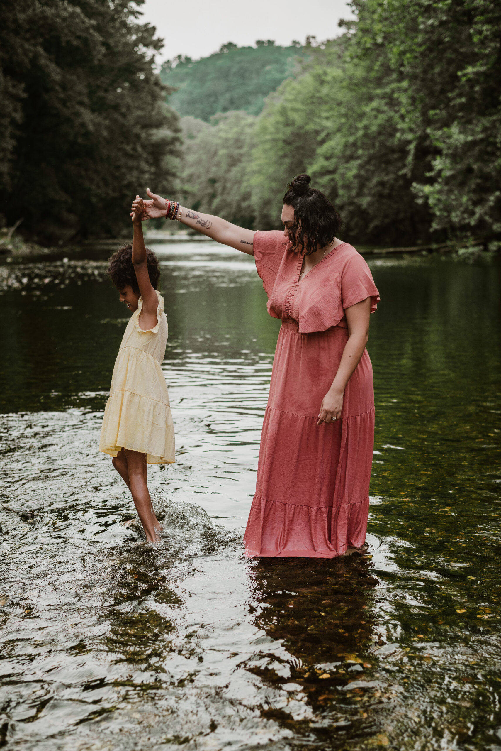 mom and daughter dancing in river for summer mini session