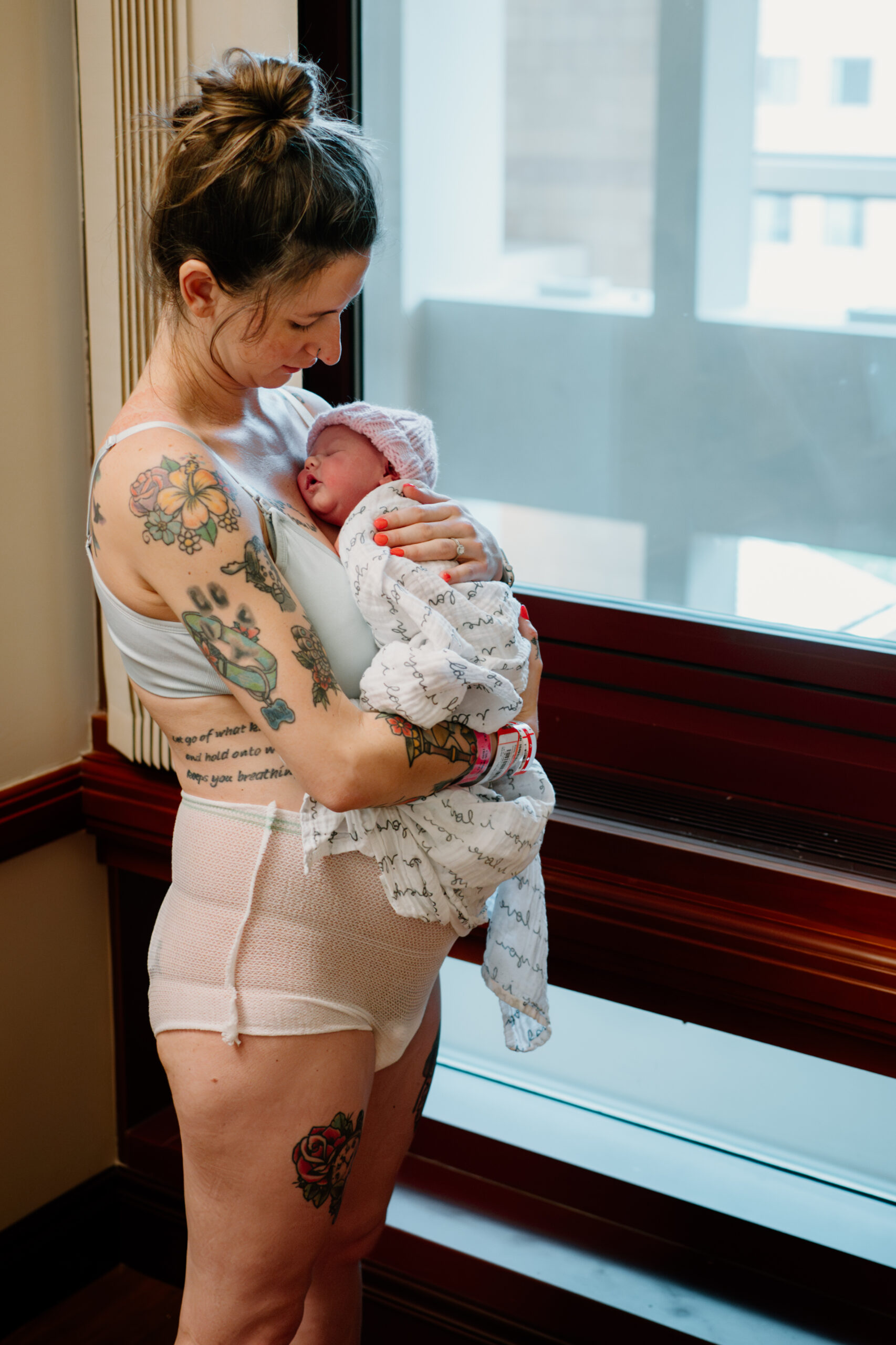 Tender moment captured: a newborn cradled in a parent's arms during a Fresh 48 photoshoot, highlighting the intimate connection and joy of those first hours.