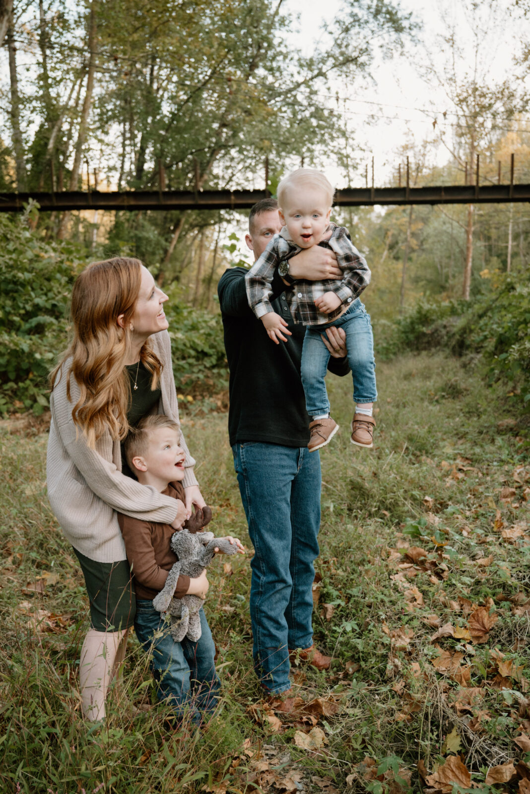 Family laughing and playing together outdoors during a stress-free photo session in Baltimore.